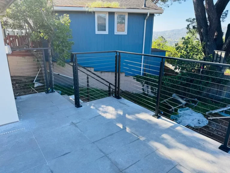 Usairs cable railing installation on a modern deck, featuring sleek stainless steel cables and sturdy black posts in San Francisco.