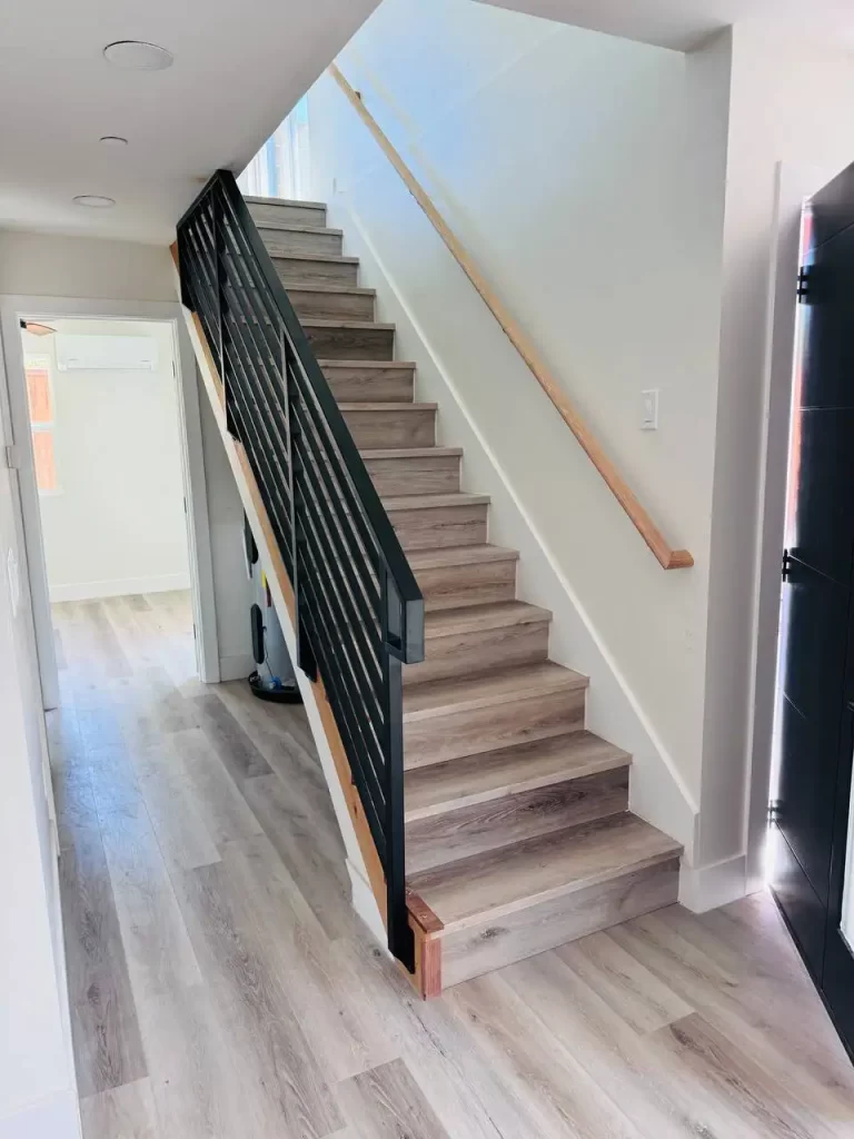 Side view of a residential patio featuring black metal railings and a staircase.