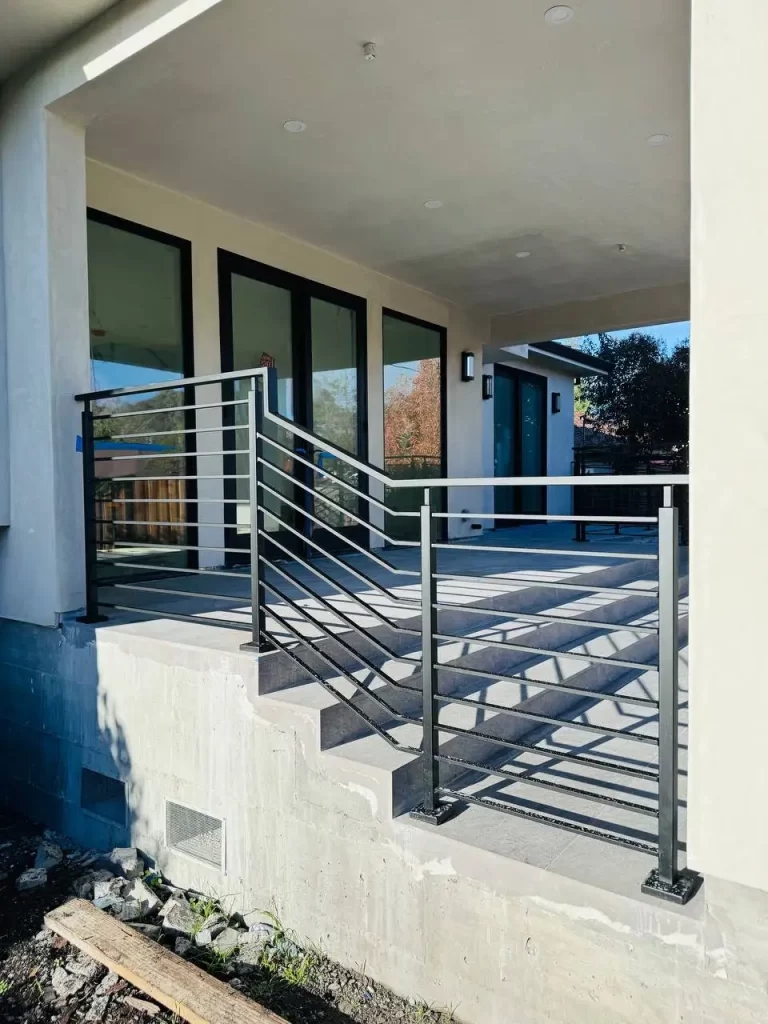 Interior staircase with black metal railings and a wooden handrail.