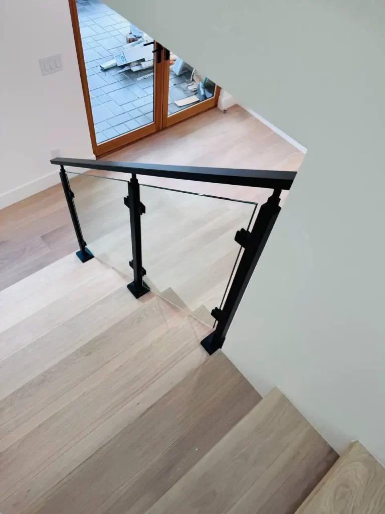 Staircase with glass railing and black metal posts, adding a contemporary touch to the interior.